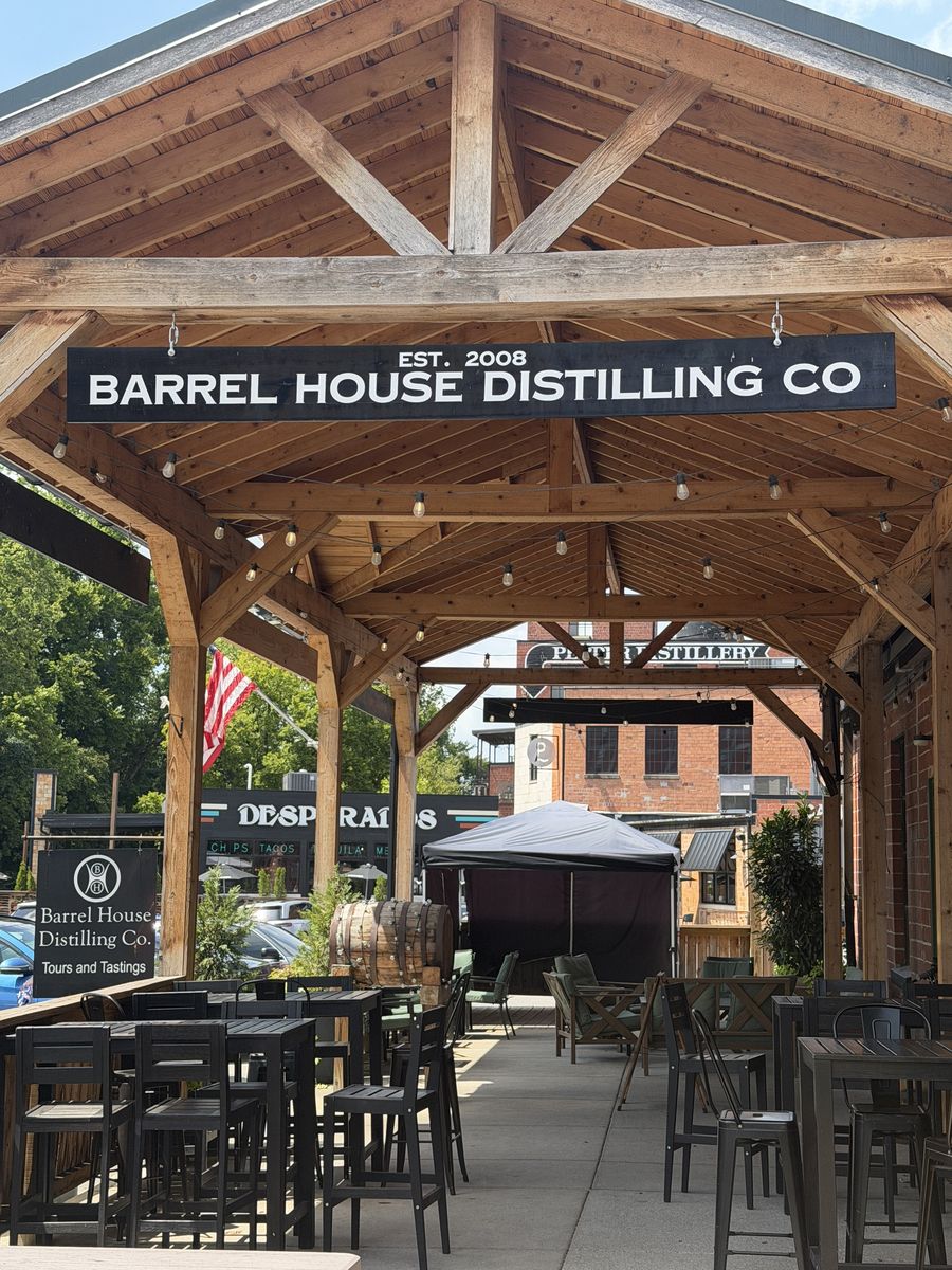 Covered timber pavilion with the Barrel House Distilling Co. sign and outdoor seating