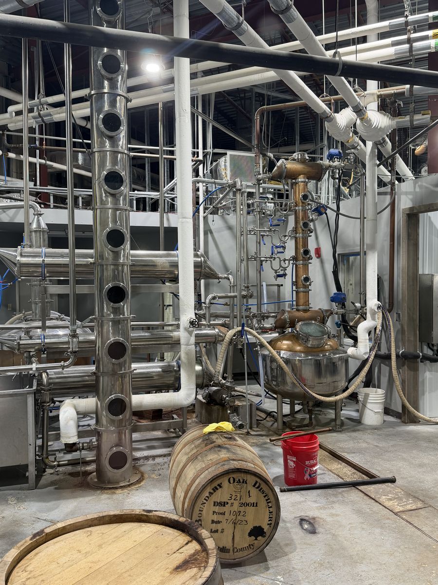 Boundary Oak still house with stainless and copper column stills and a barrel on the floor