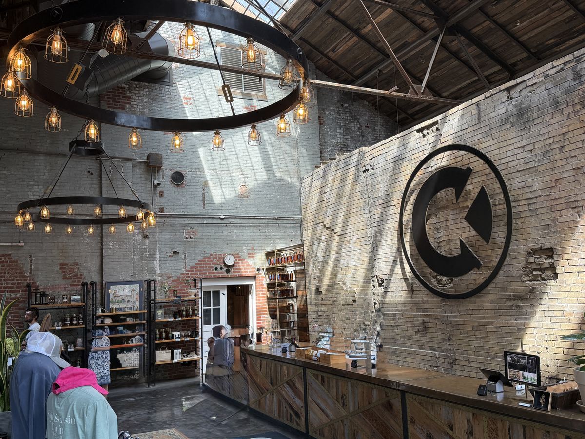 Castle and Key retail hall inside a restored warehouse with ring chandeliers and brick walls