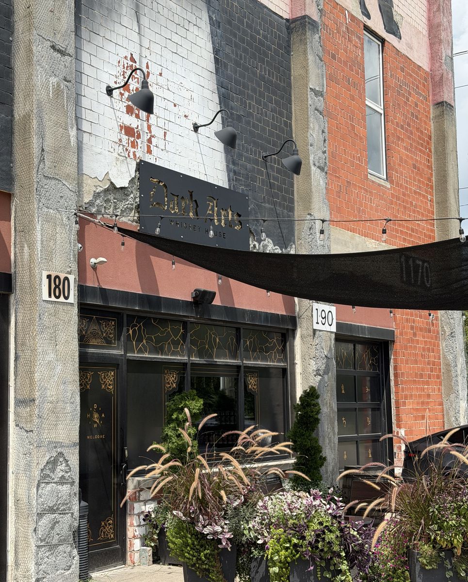 Dark Arts Whiskey House storefront on Manchester Street with planters and awning