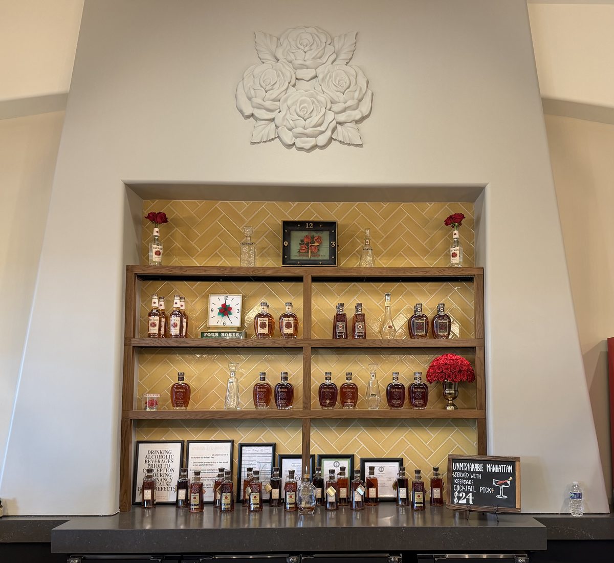 Four Roses bottle display with rose sculpture and herringbone tile