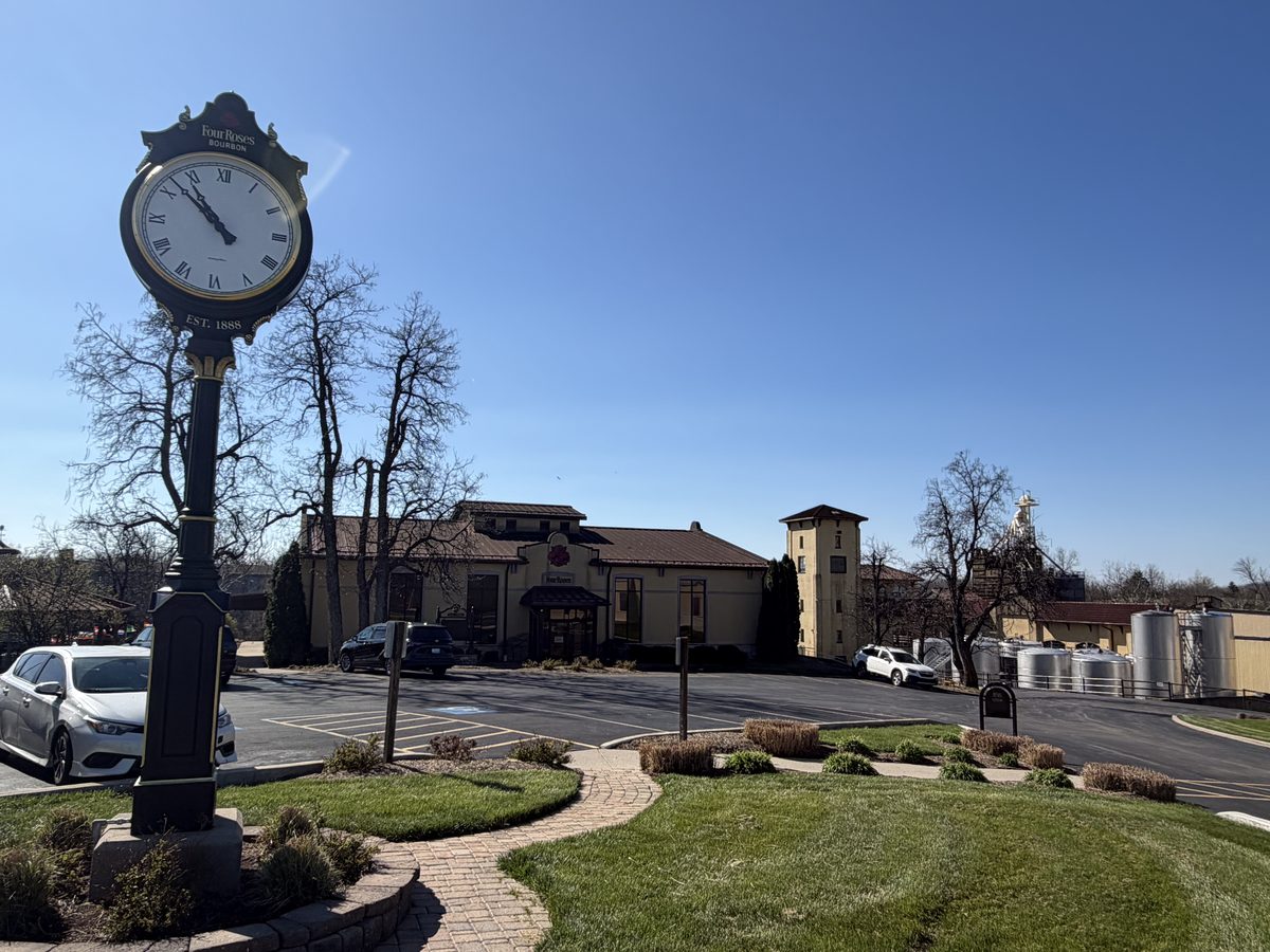 Four Roses Bourbon Est. 1888 clock with Spanish Mission distillery behind