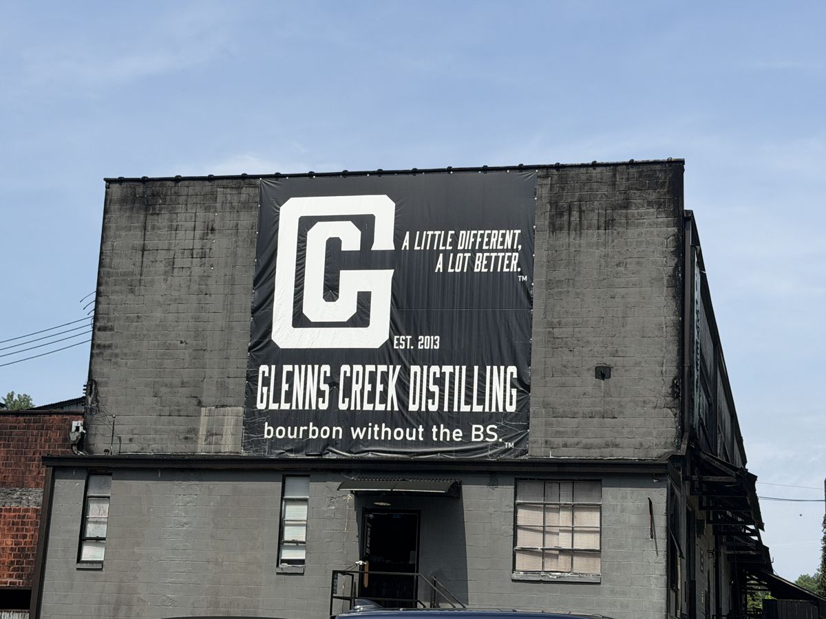 Glenns Creek Distilling banner reading bourbon without the BS on a weathered stone building