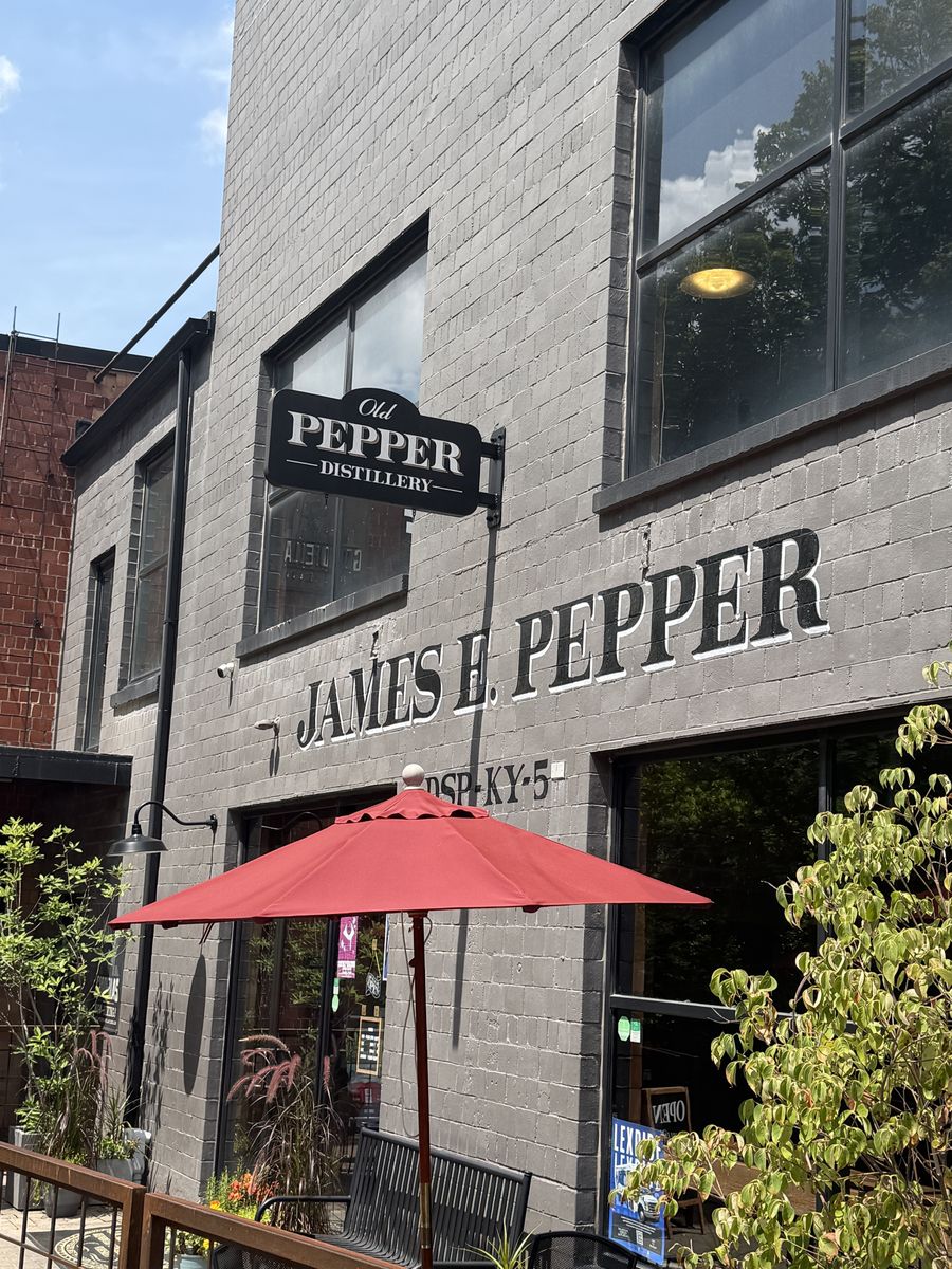 James E. Pepper distillery entrance on Manchester Street with a red umbrella and patio