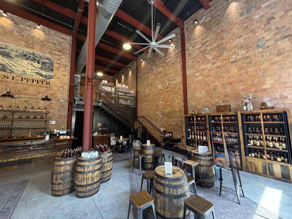 Interior of James E. Pepper with barrel tables and stools in a tall brick room