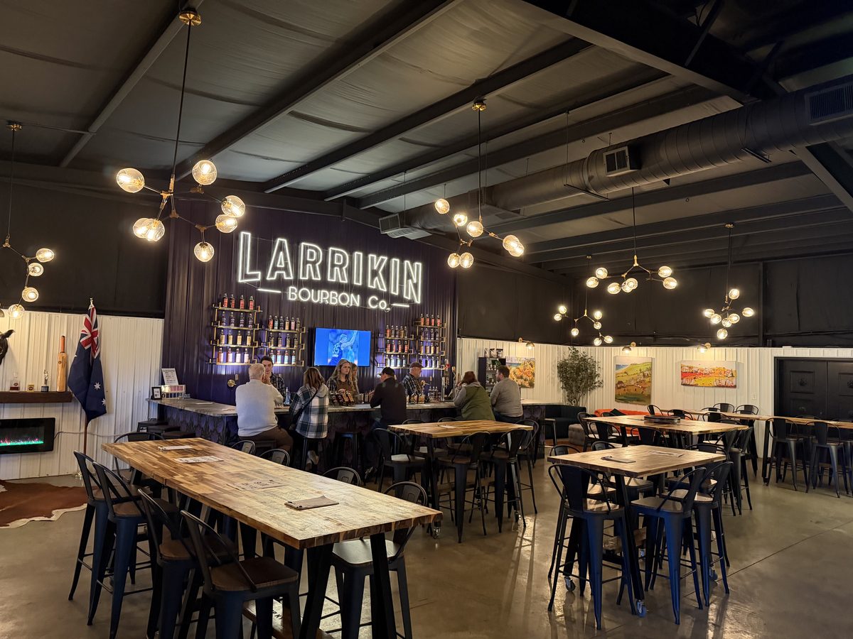 Larrikin Bourbon tasting room with neon sign and industrial bar seating