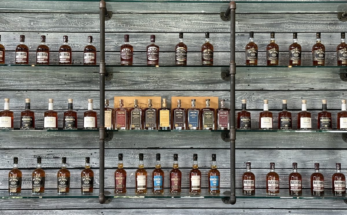 Lux Row bottle display wall featuring Rebel, Ezra Brooks, and Blood Oath