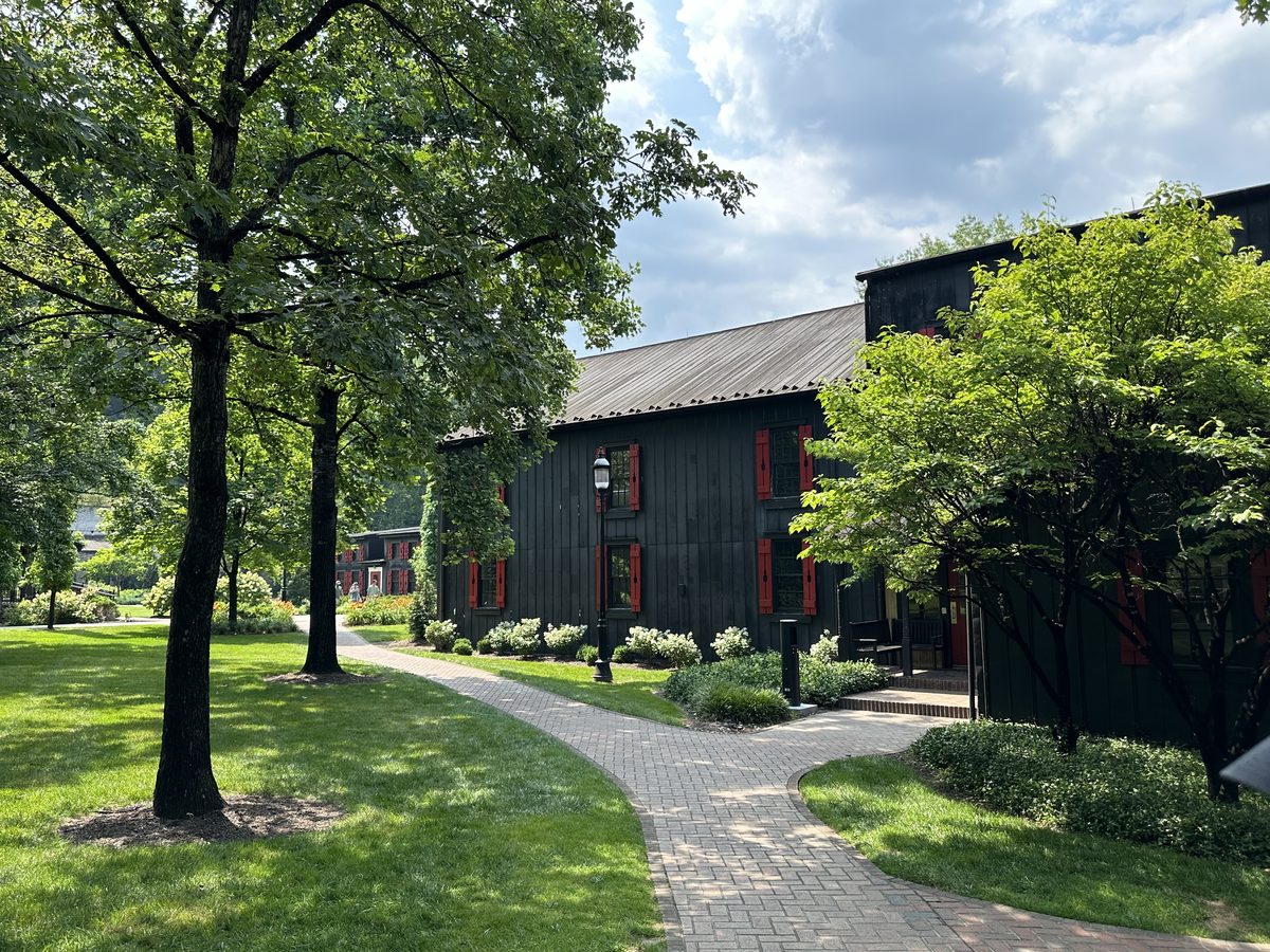 Maker's Mark campus grounds with brick walkway and black buildings with red shutters