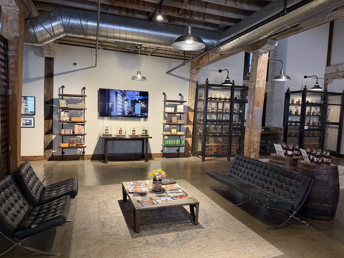 Kentucky Peerless lounge with leather seating, exposed beams, and bottle displays