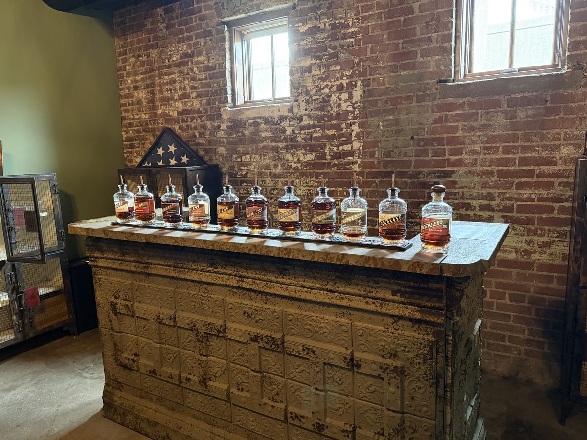 Full Peerless bourbon and rye lineup on vintage tin-pressed bar