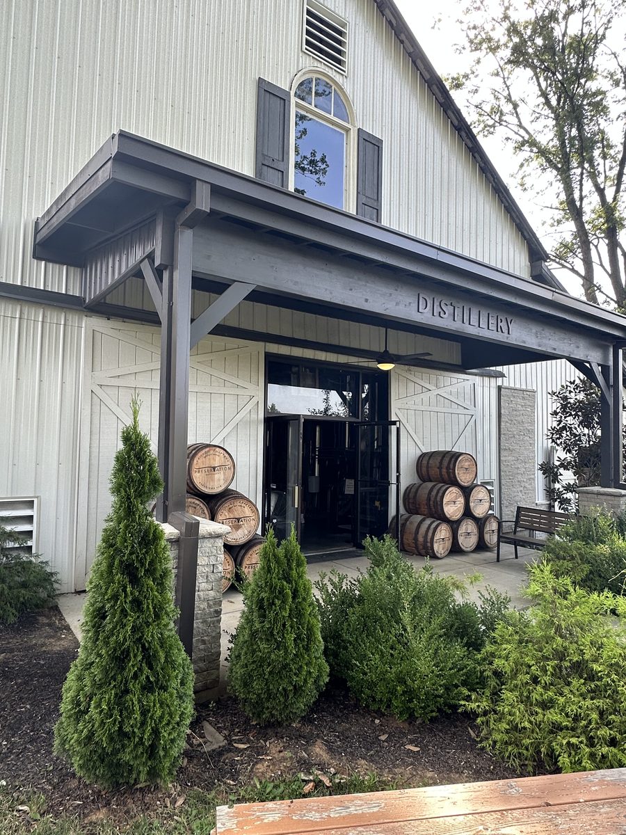 Preservation Distillery entrance with barrels and barn-style architecture