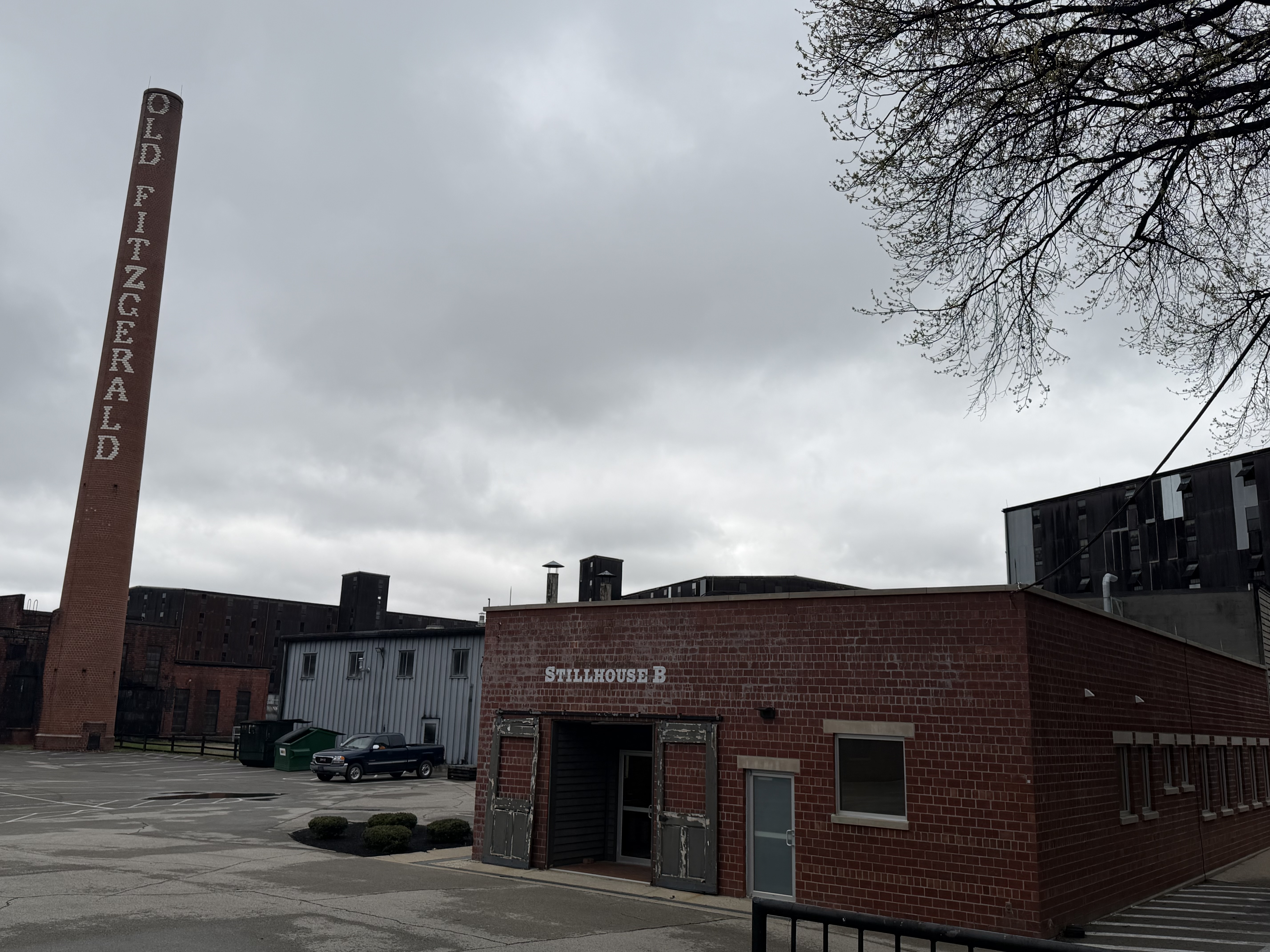 Old Fitzgerald smokestack towering over the Stitzel-Weller campus with Stillhouse B brick building in the foreground