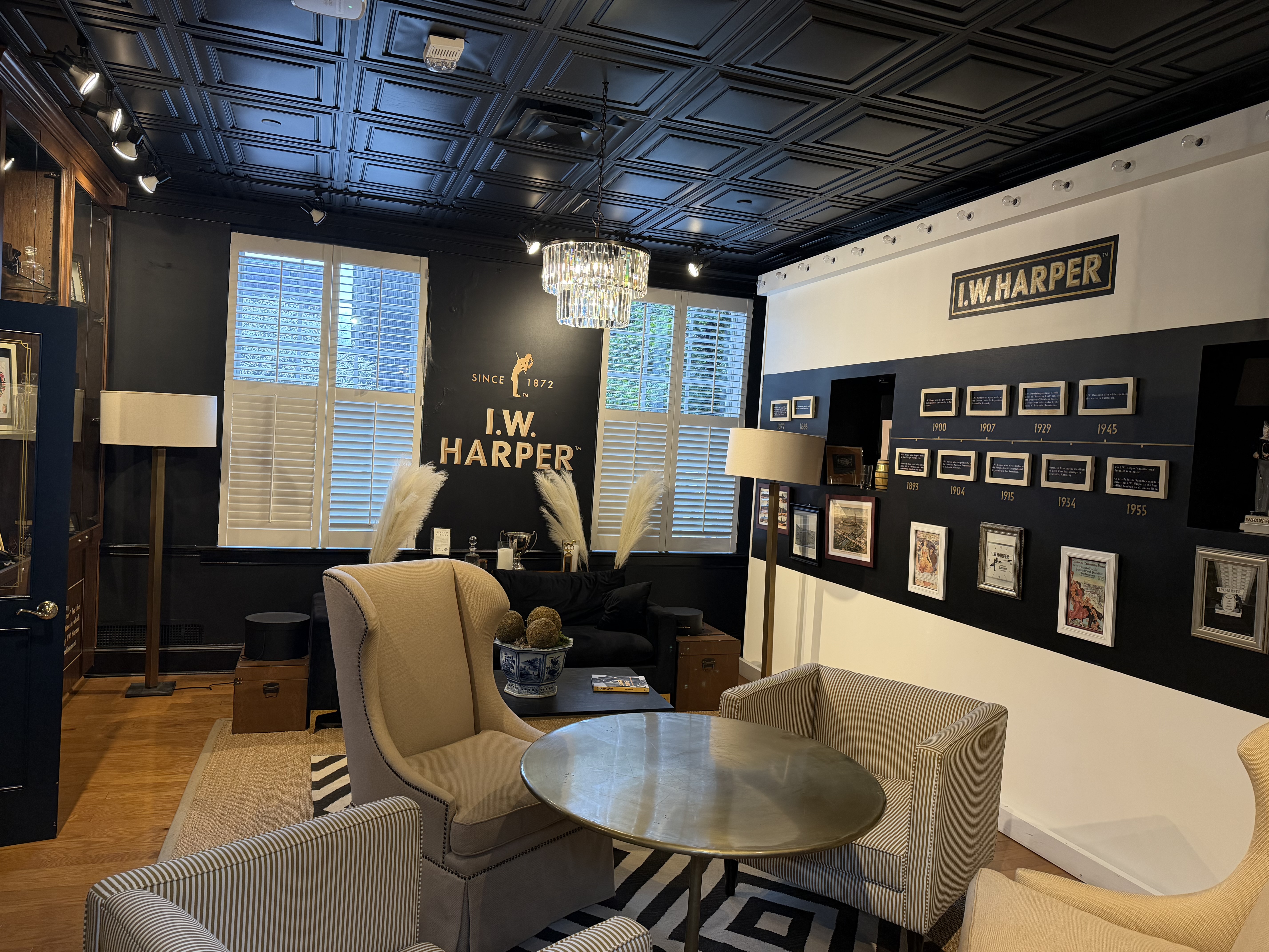 I.W. Harper tasting lounge at Stitzel-Weller with tin ceiling, chandelier, wingback chairs, and vintage advertisement wall